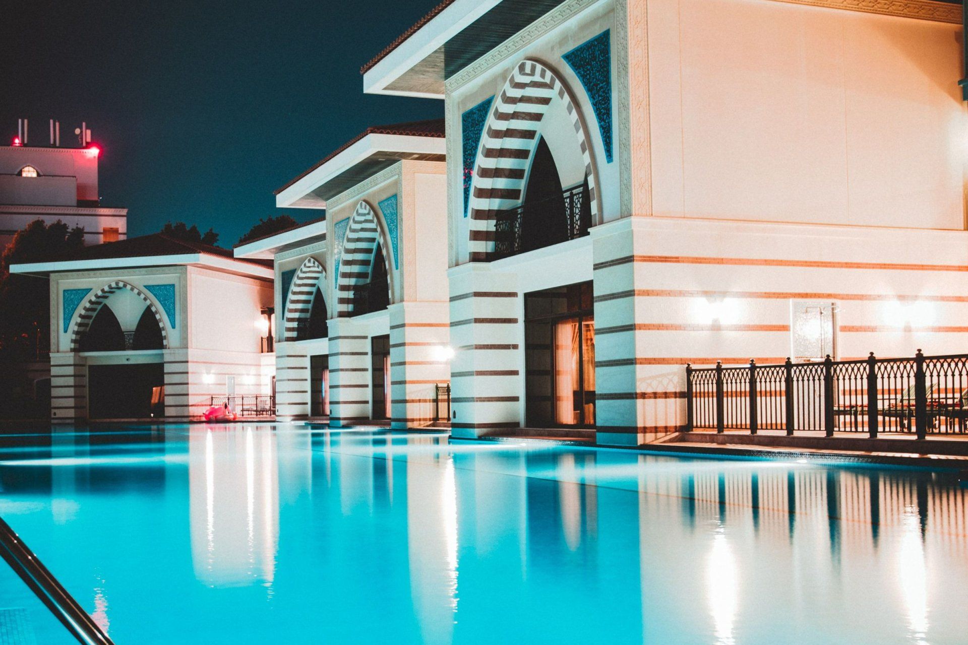 a swimming pool in front of a building at night