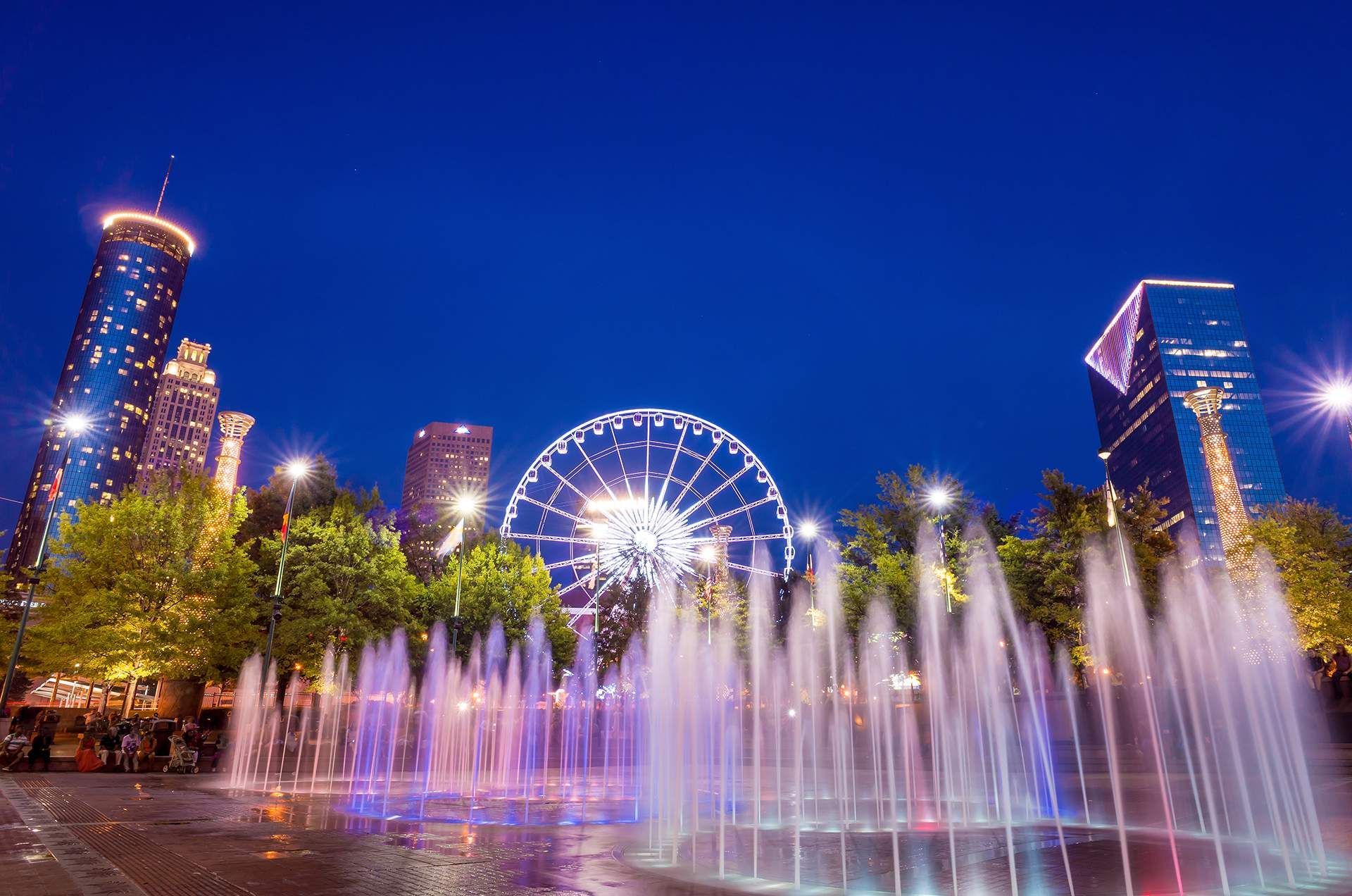 a fountain with a ferris wheel in the background