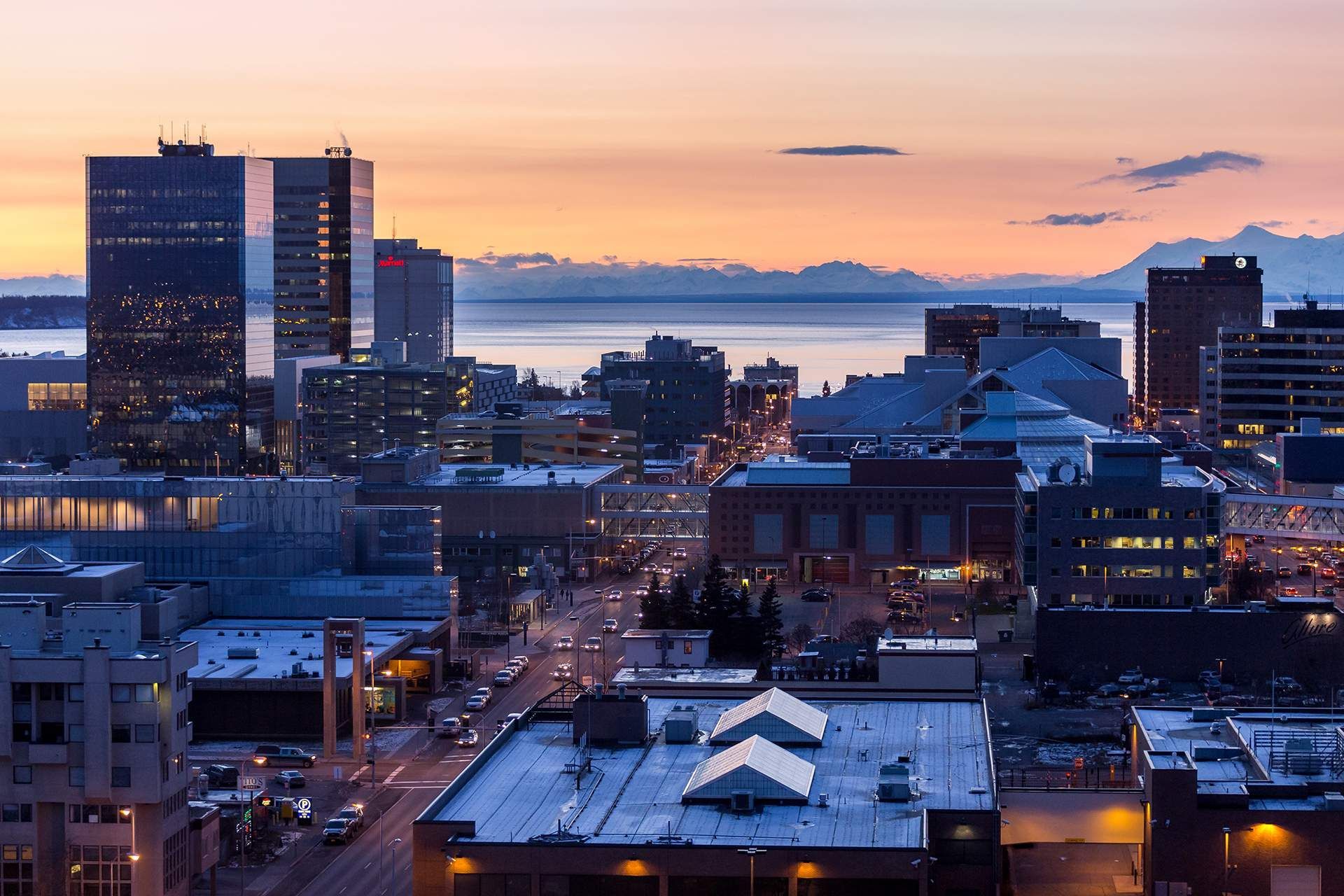 an aerial view of a city at sunset with a building that has the letter o on it