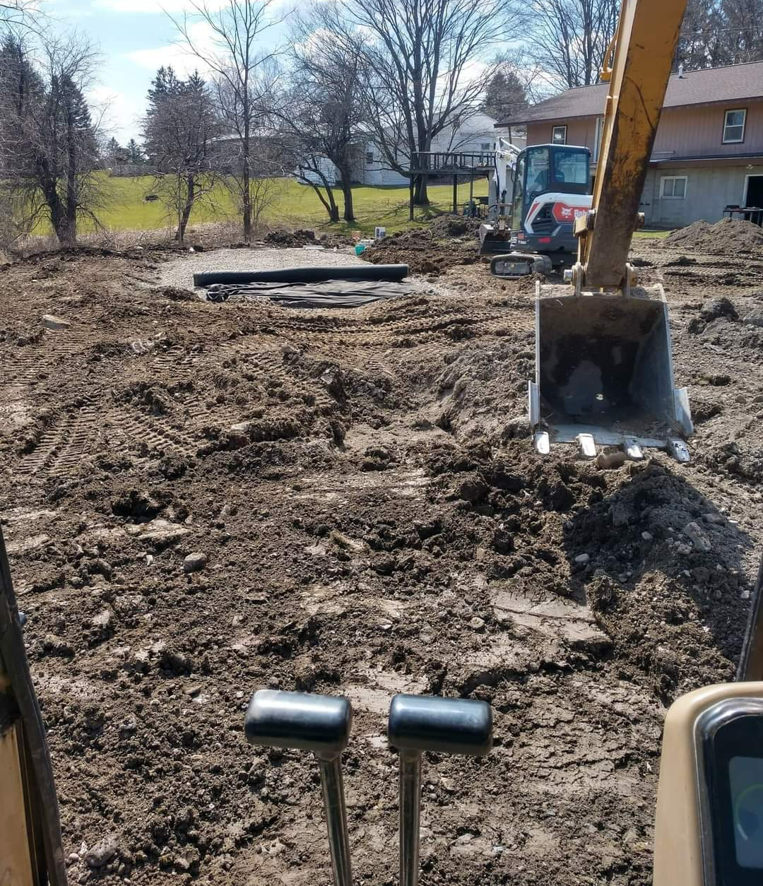 a bulldozer is digging a hole in a dirt field