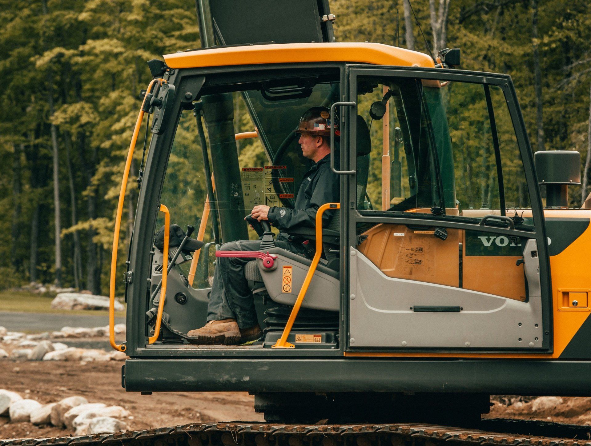 a man sits in the cab of a volvo excavator