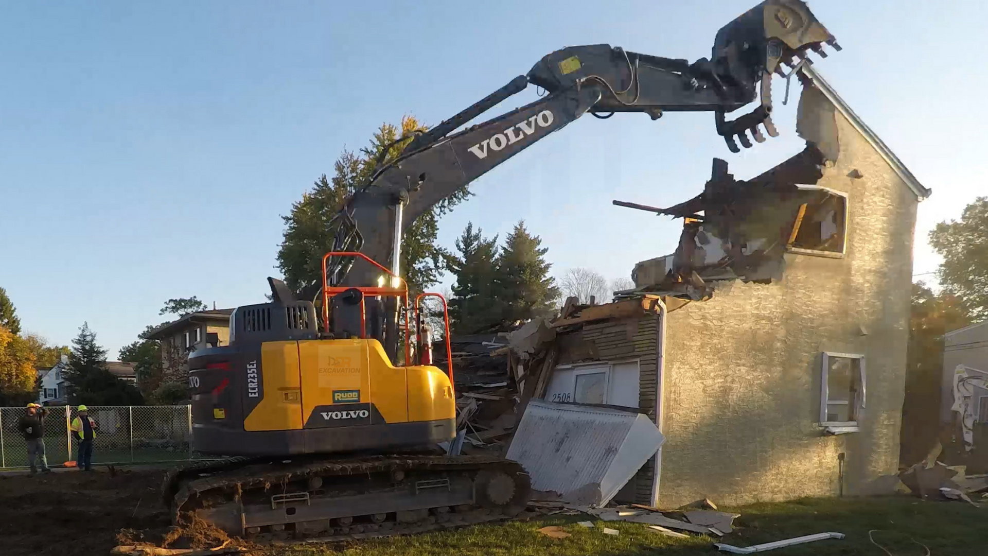 A yellow excavator is working on a construction site