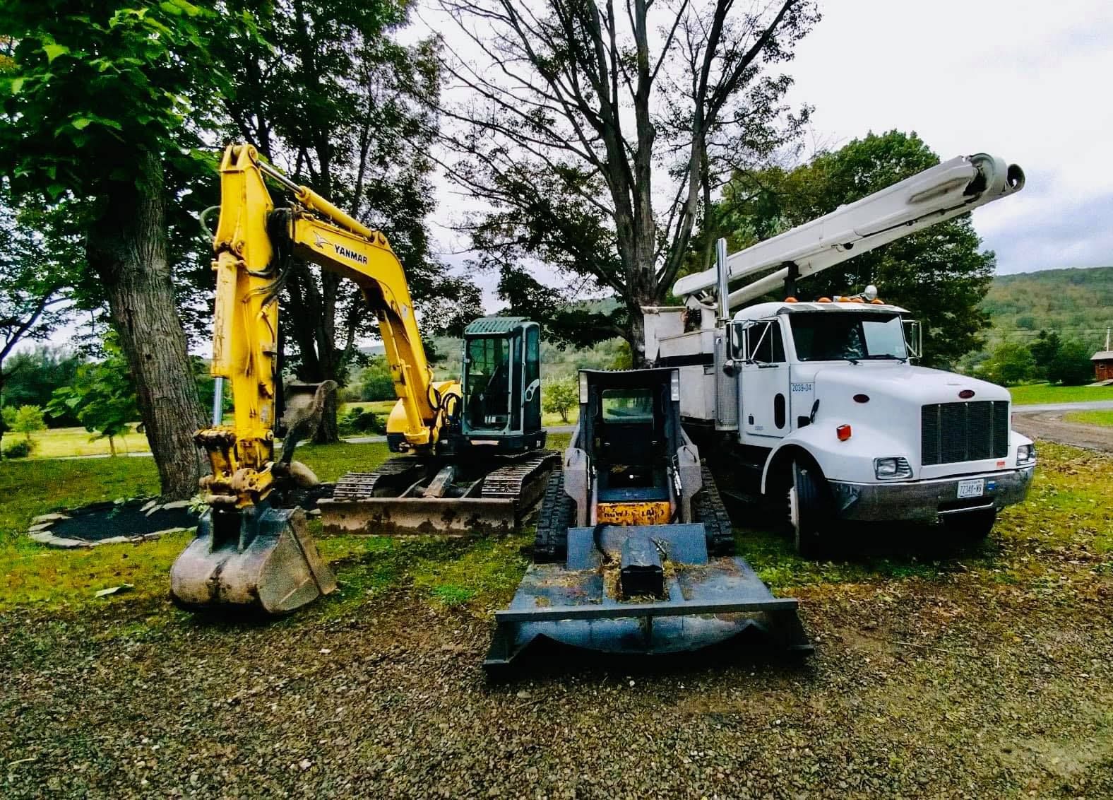 a yanmar excavator sits next to a peterbilt truck