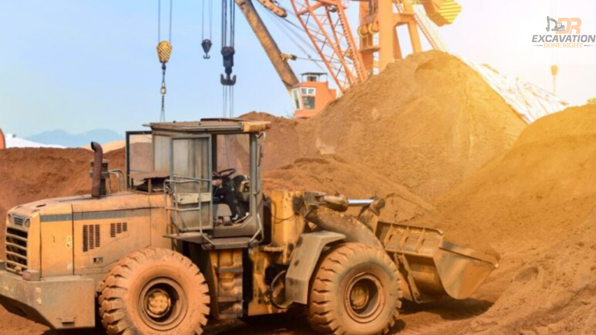 A bulldozer is driving through a pile of dirt in a construction site.