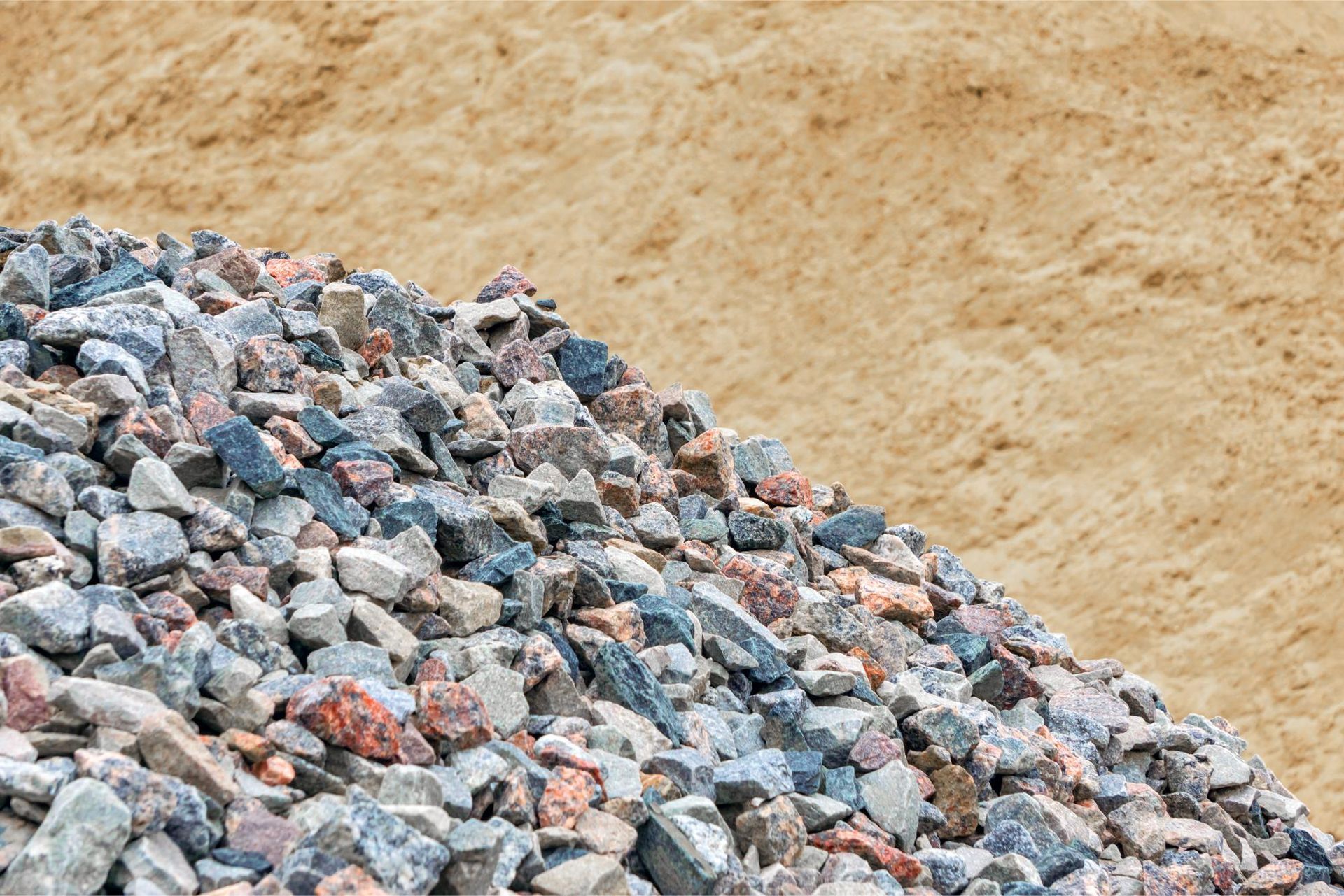A pile of rocks sitting on top of a pile of sand.