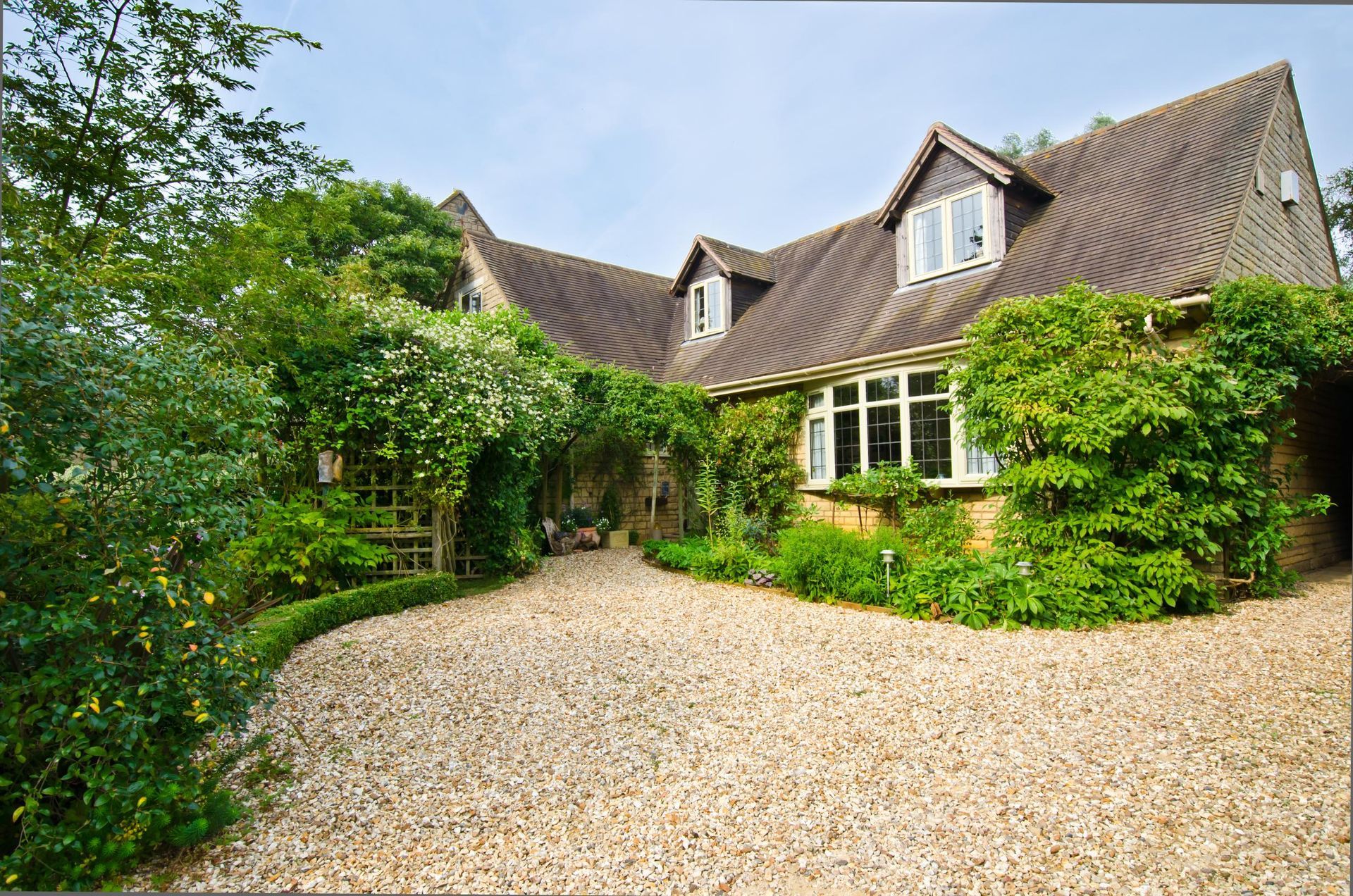 A large house with a gravel driveway leading to it