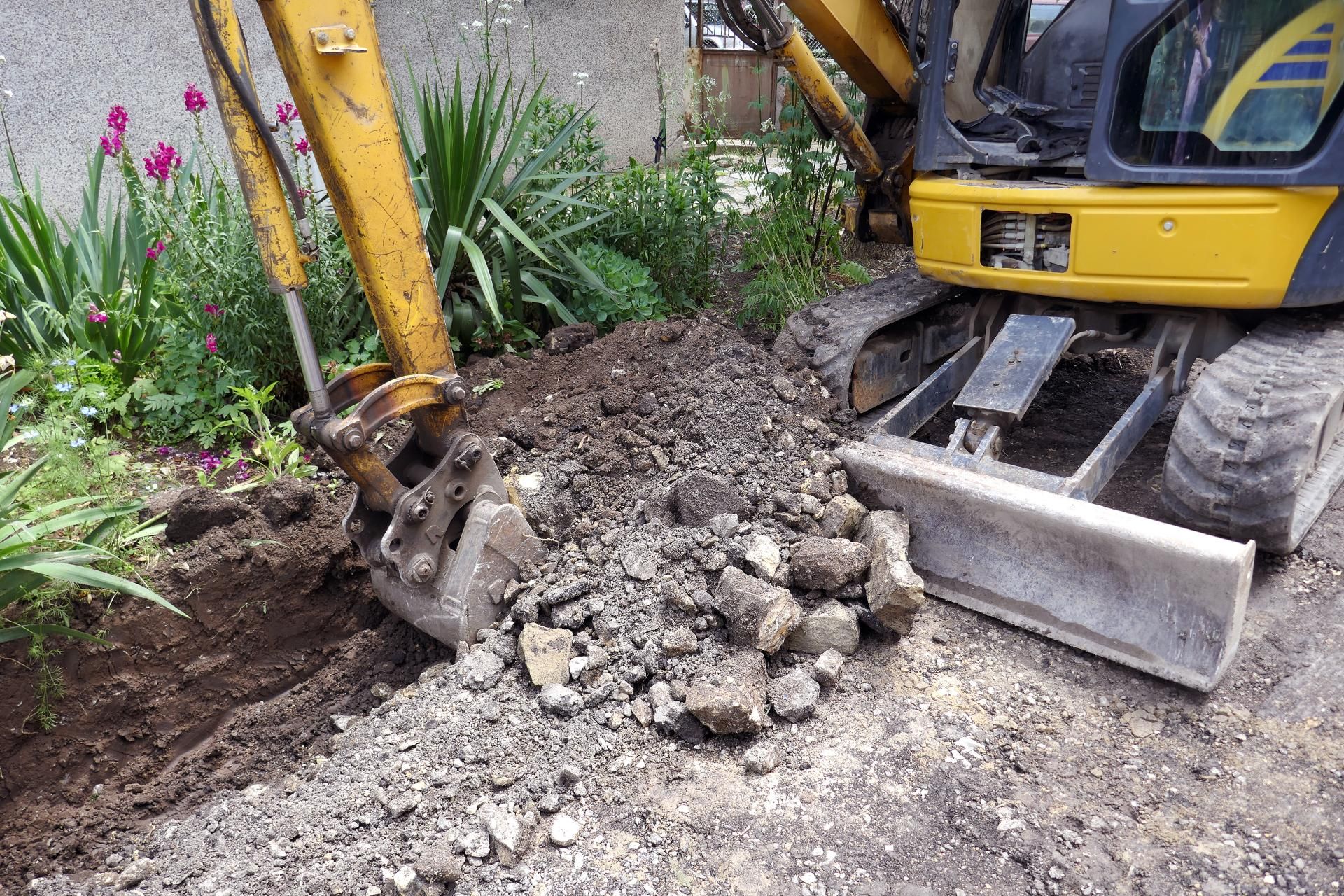 a yellow excavator is digging a hole in the ground