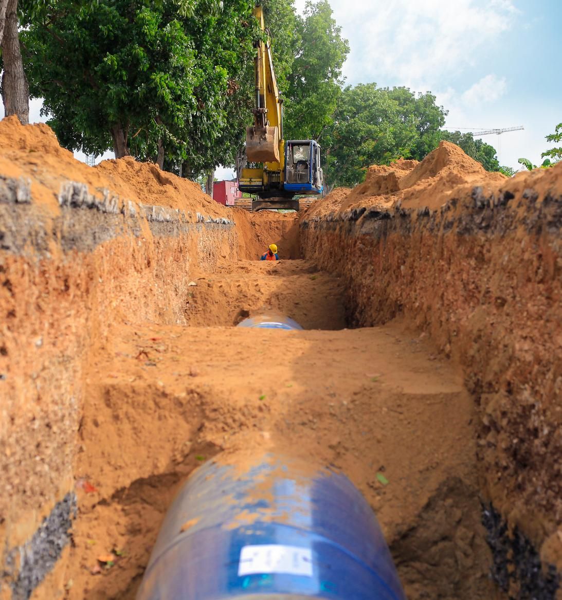 a blue pipe is being installed in a trench