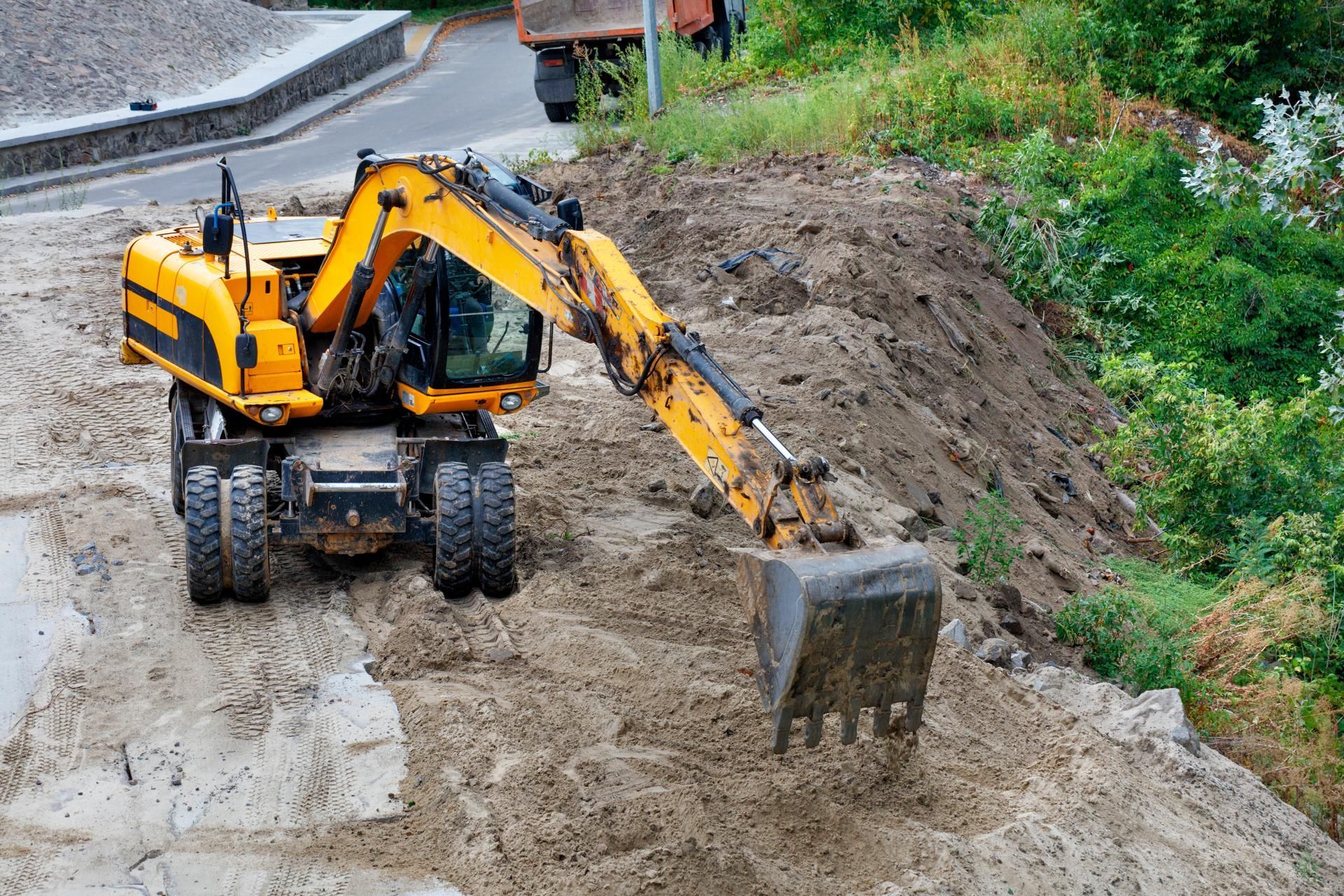 A yellow excavator is moving dirt on a construction site.