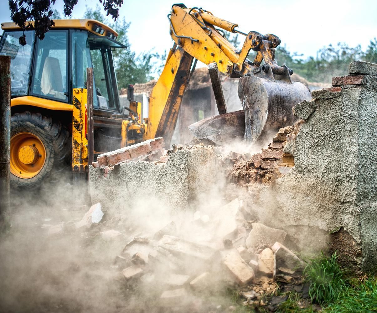 a yellow bulldozer is demolishing a brick building