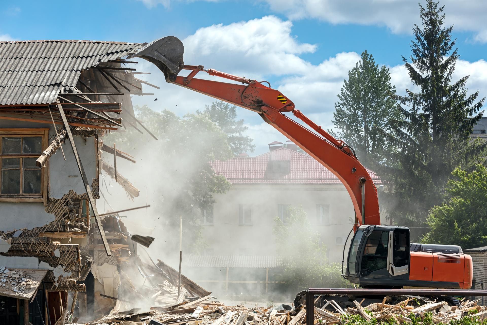 a large orange excavator is demolishing a building