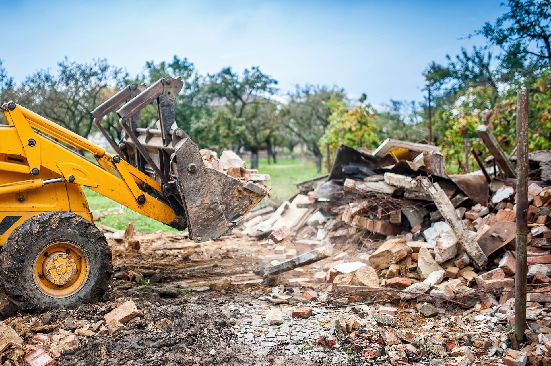 a yellow bulldozer is working on a pile of rubble
