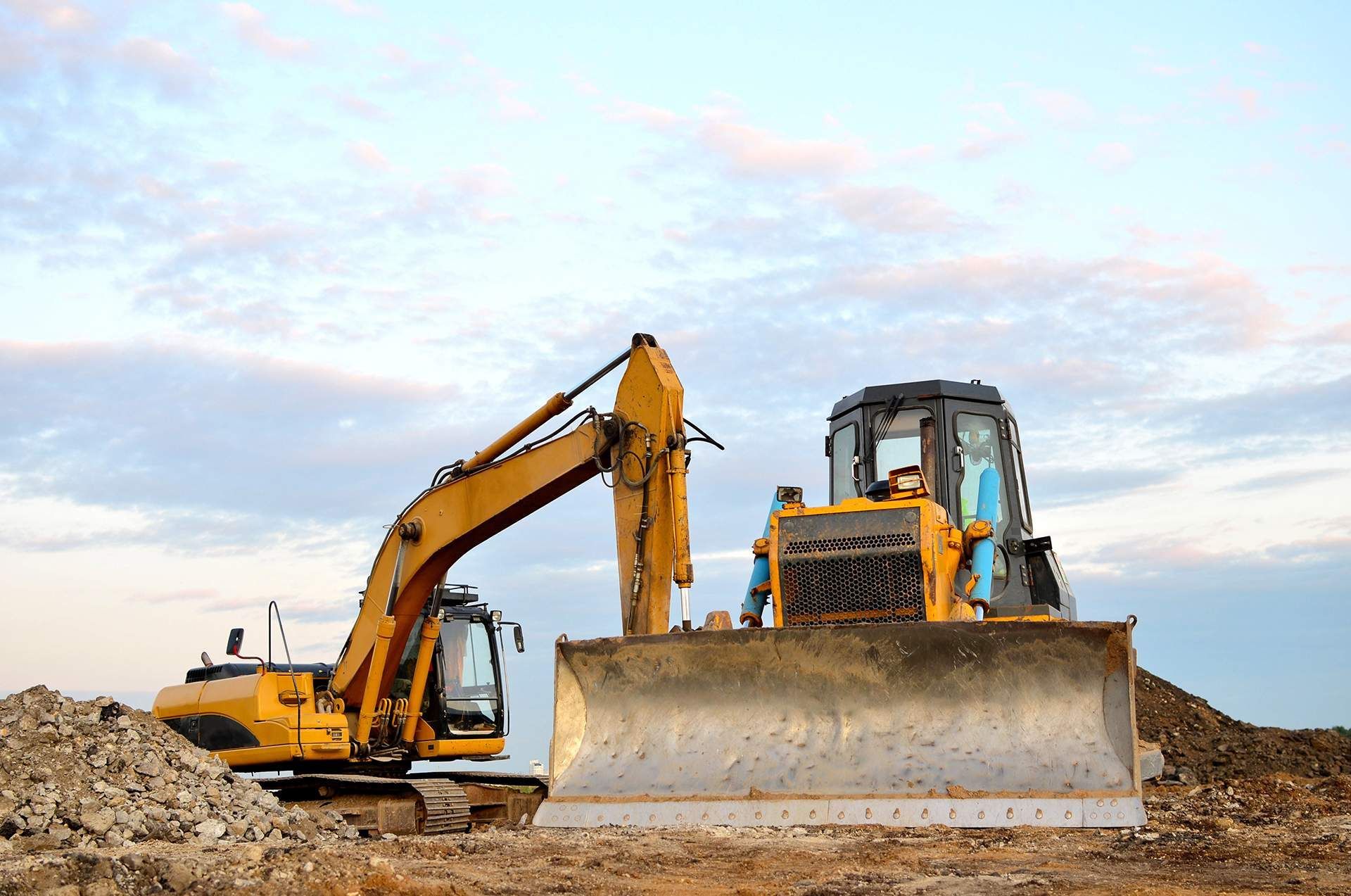 A bulldozer and an excavator are working on a construction site.