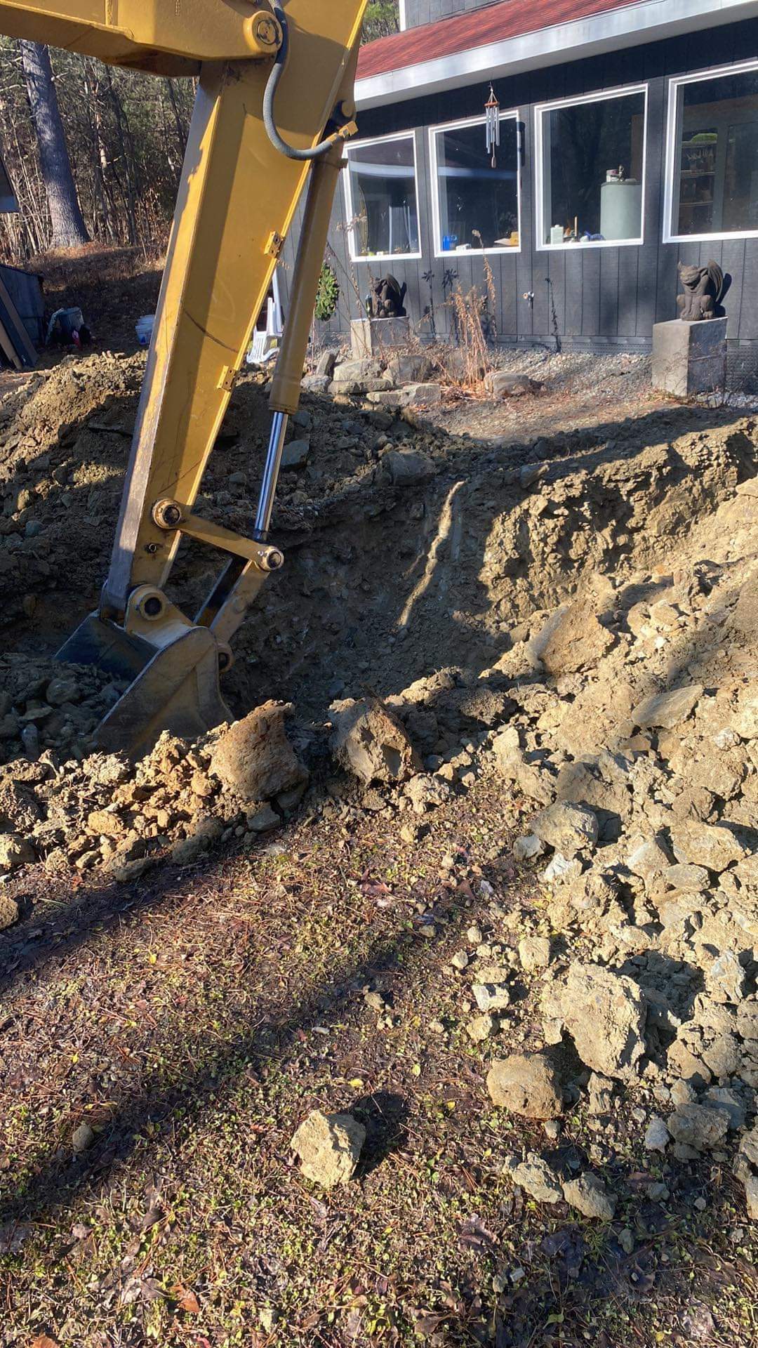 an excavator is digging a hole in front of a house