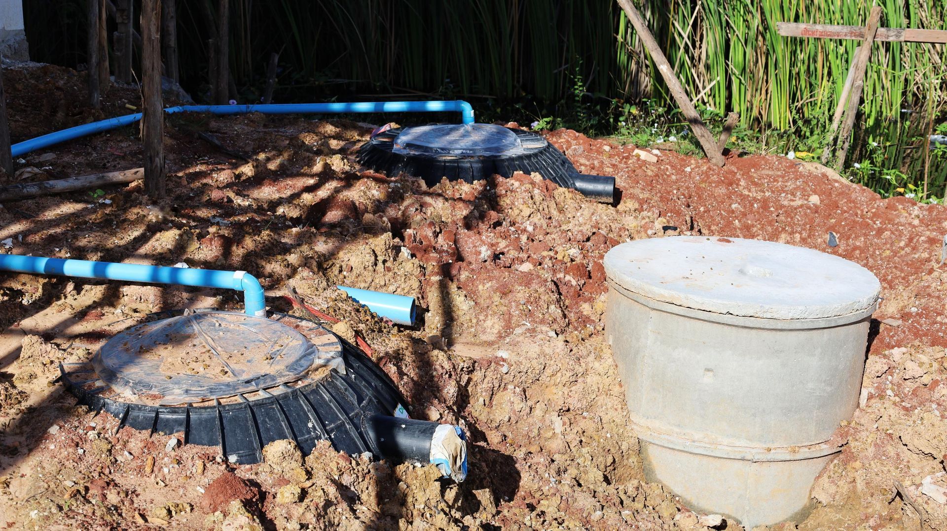 A septic tank is sitting in the middle of a dirt field.