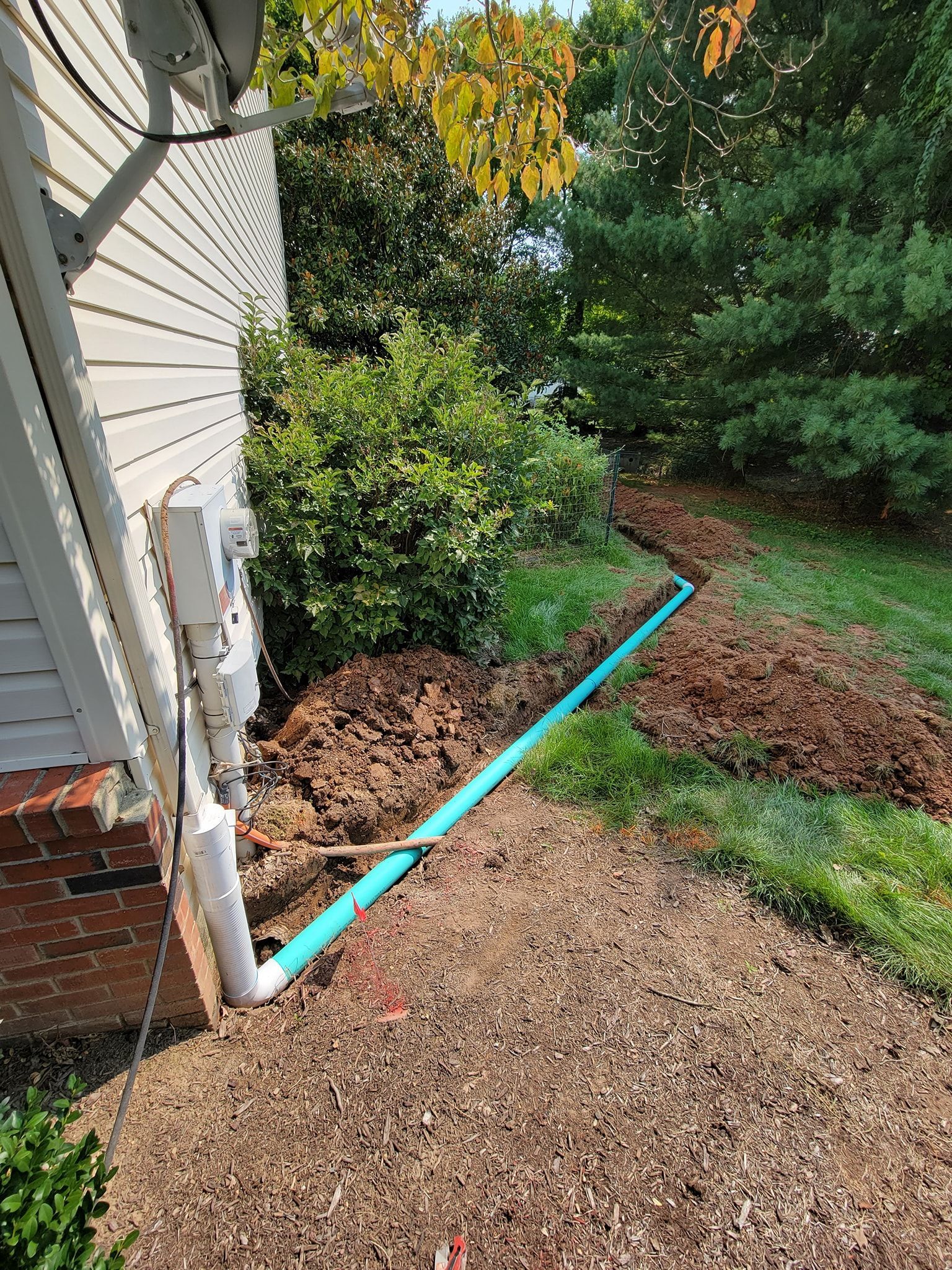 a blue pipe is being installed on the side of a house