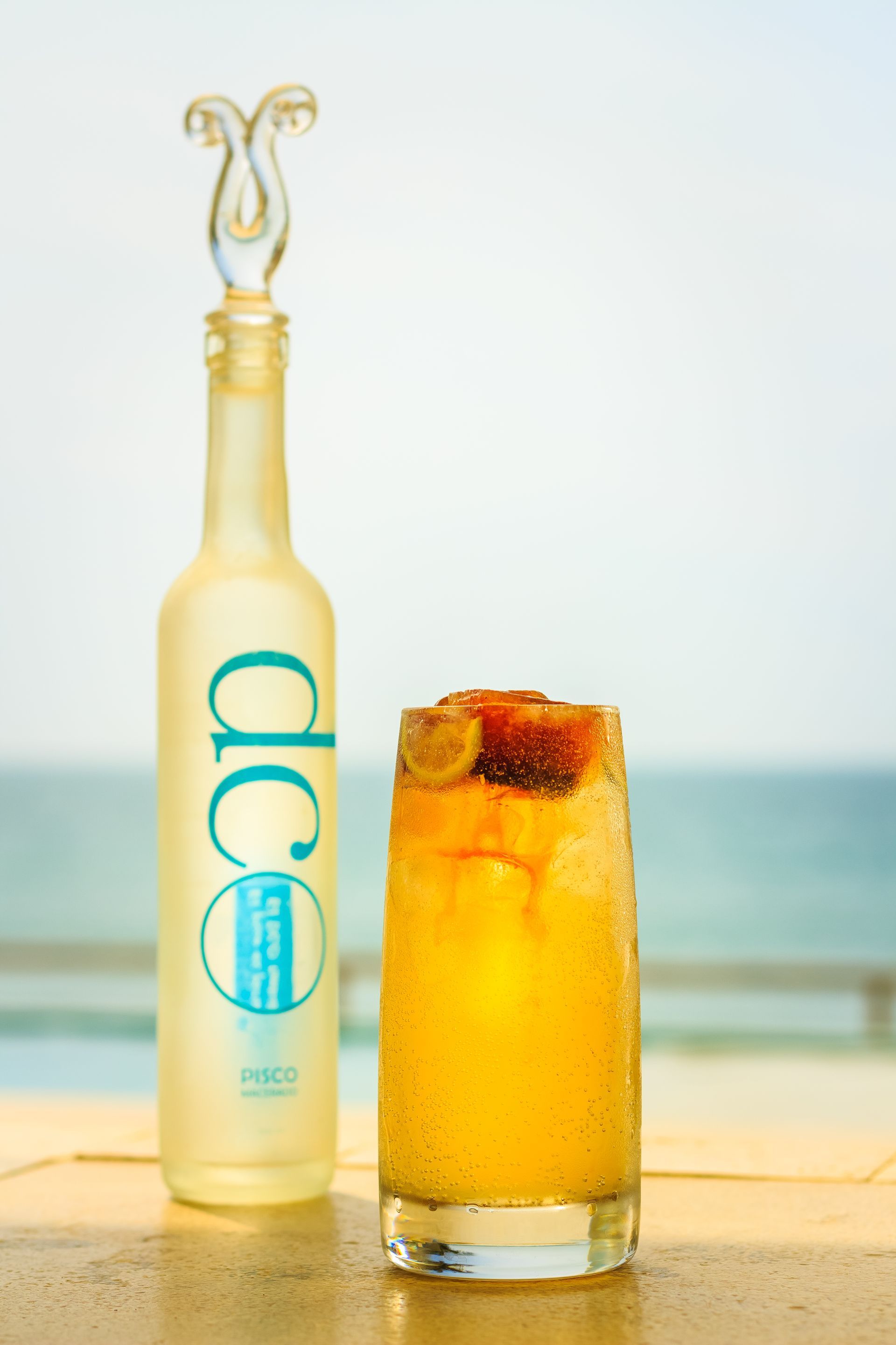 A bottle of dce next to a glass of orange juice