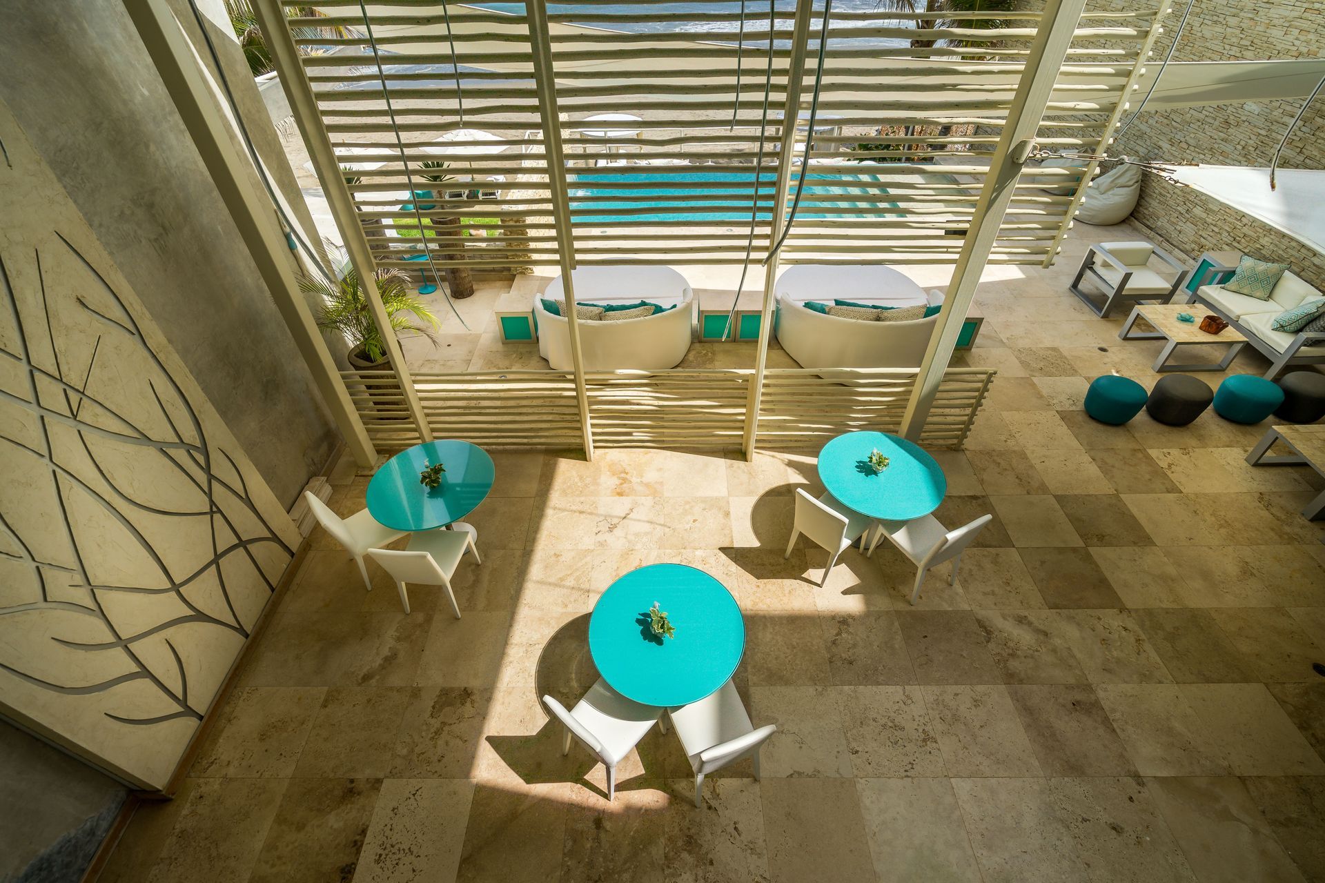 An aerial view of a patio with tables and chairs and a pool.