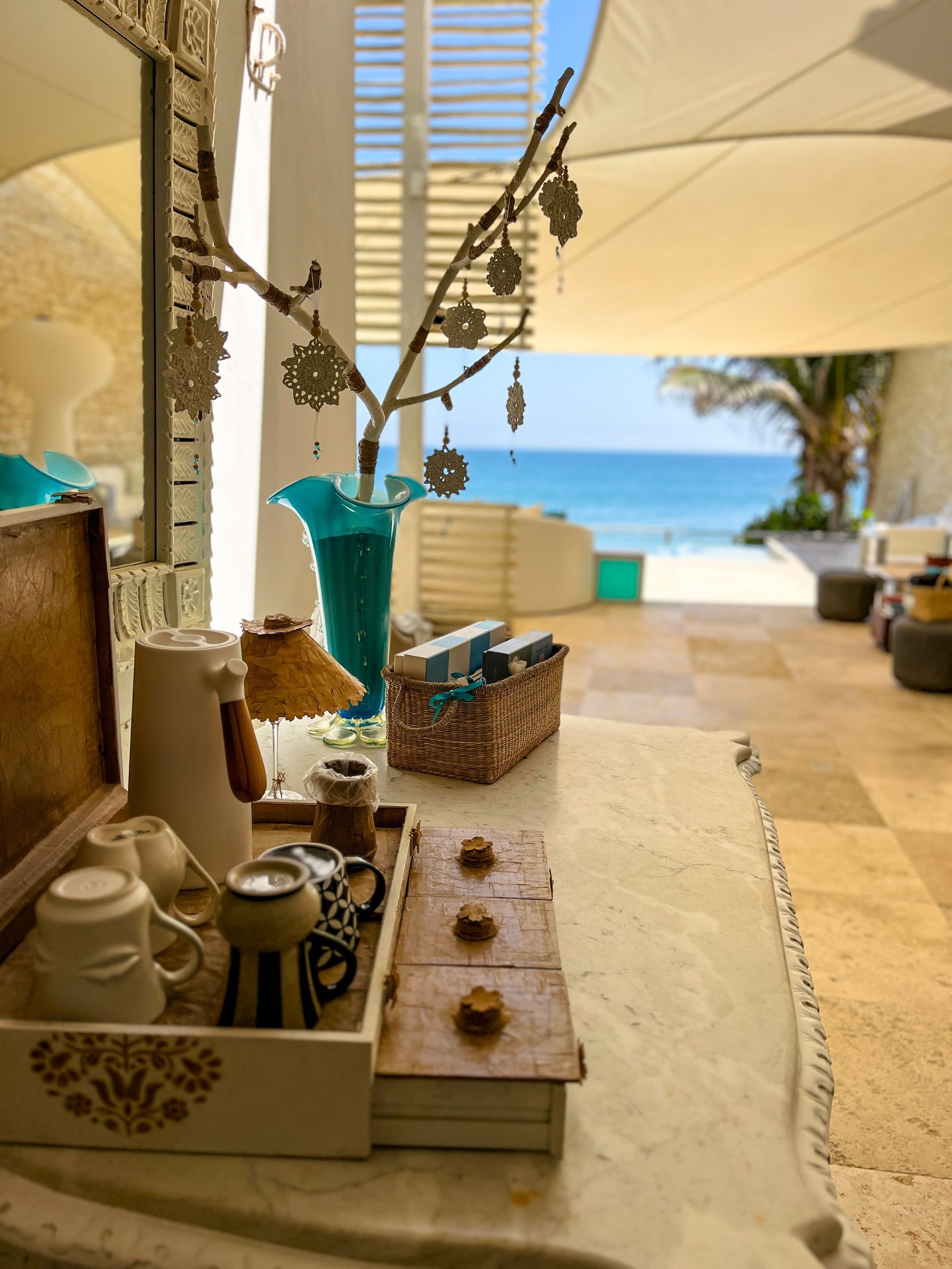 A table with a tray of coffee cups on it and a view of the ocean.