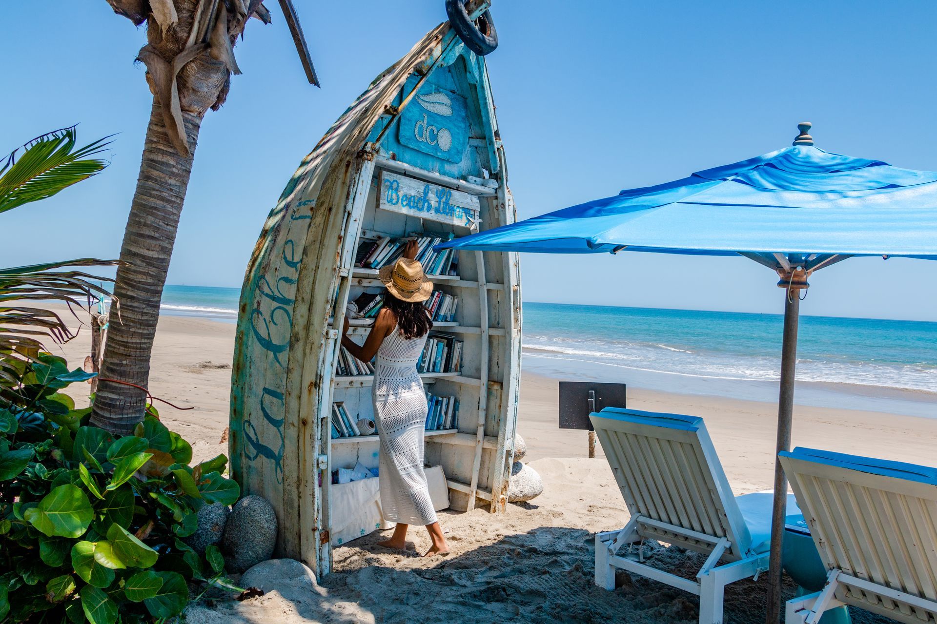 A woman is standing in a small hut on the beach.