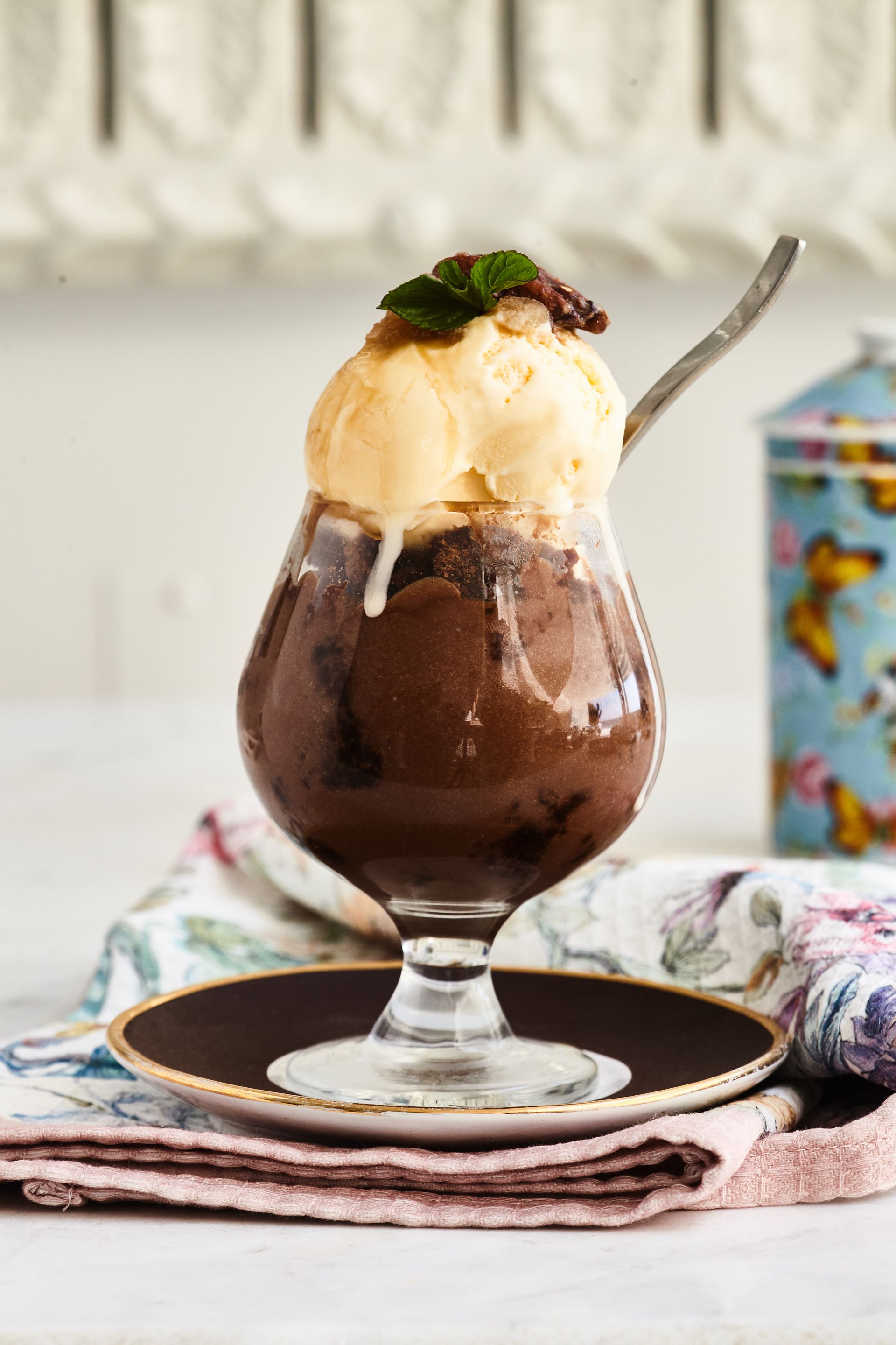 A glass of chocolate ice cream with a spoon in it
