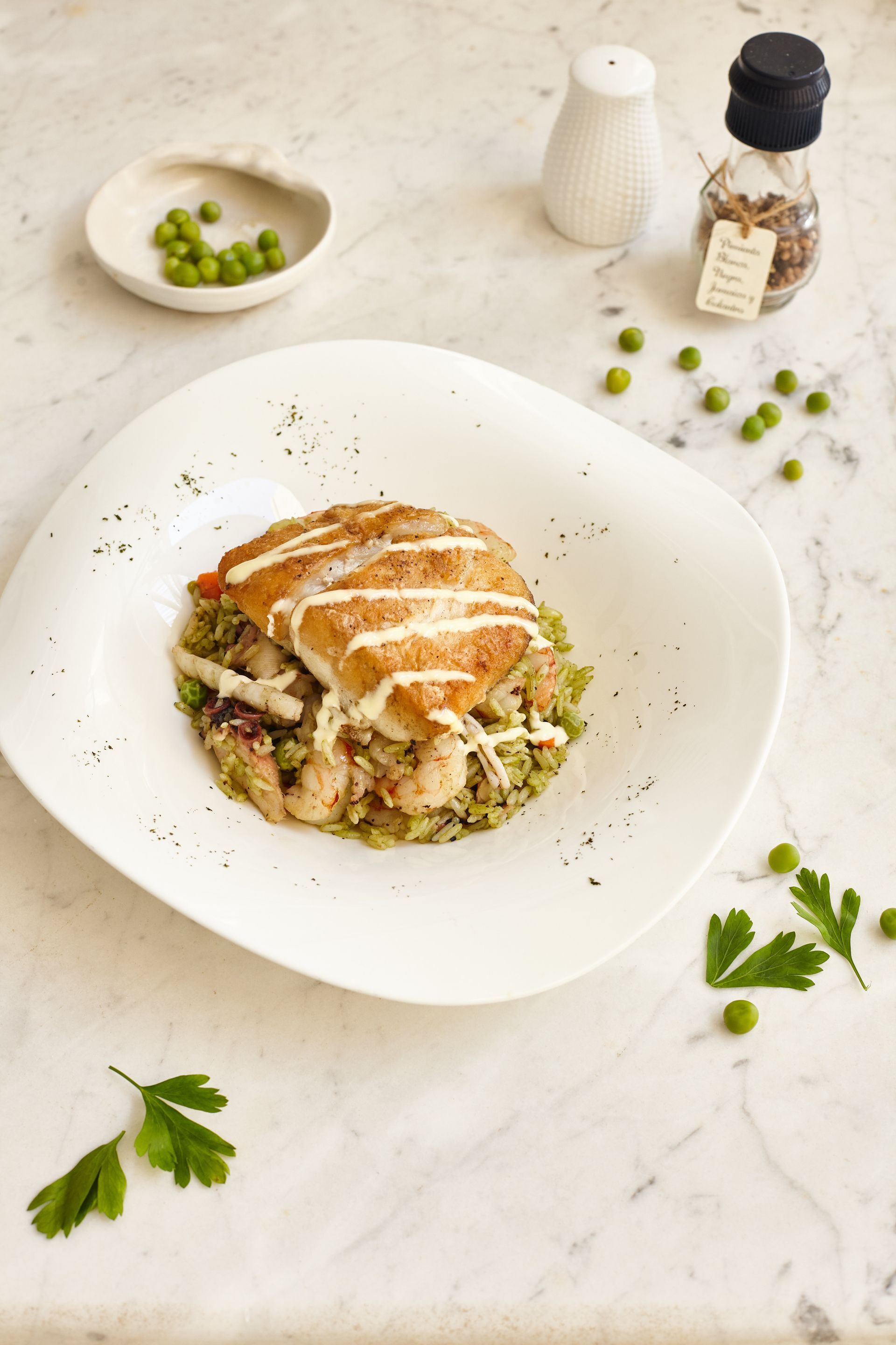 A white plate topped with a piece of meat and vegetables on a table.