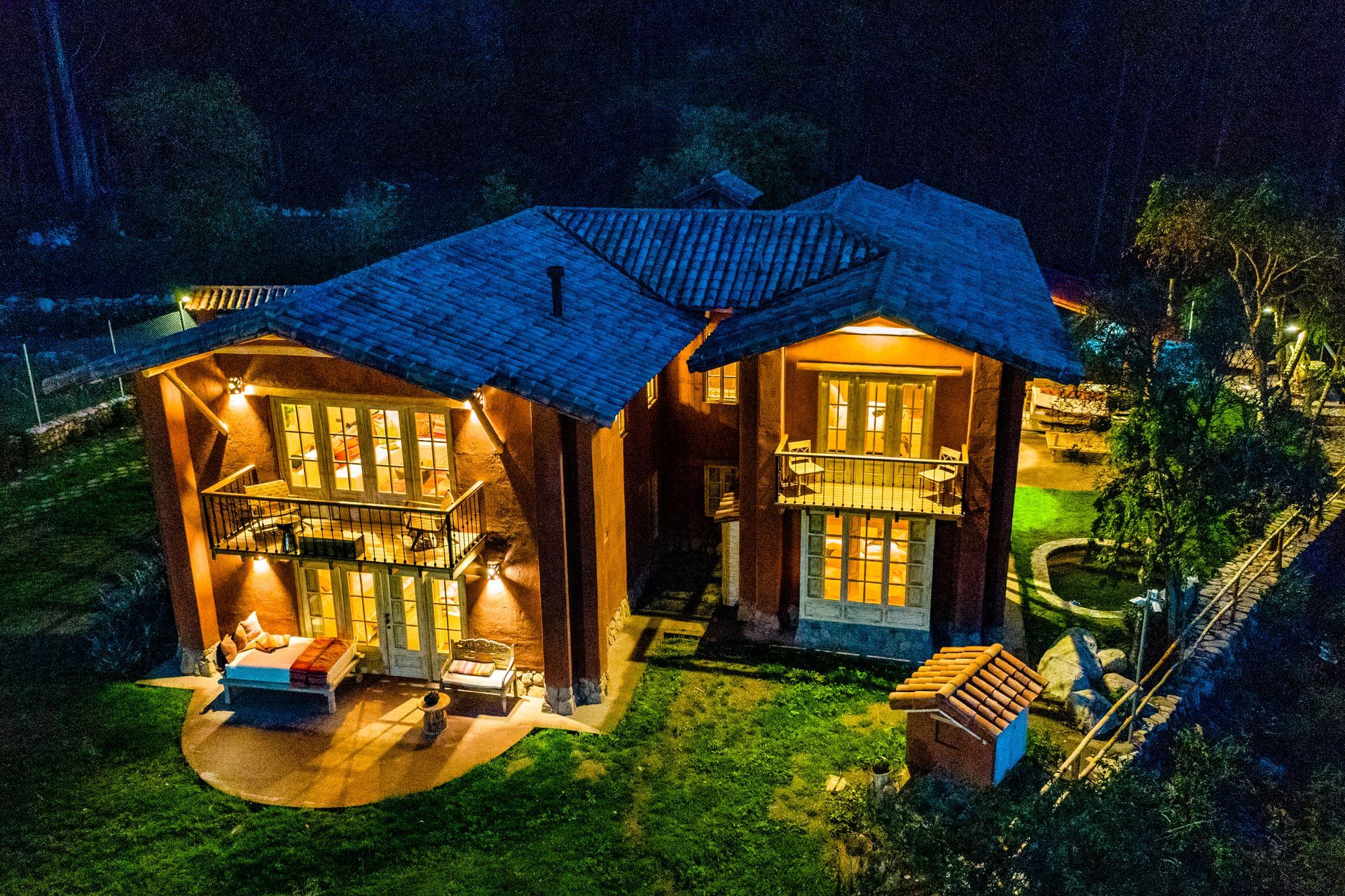 An aerial view of a large house lit up at night.