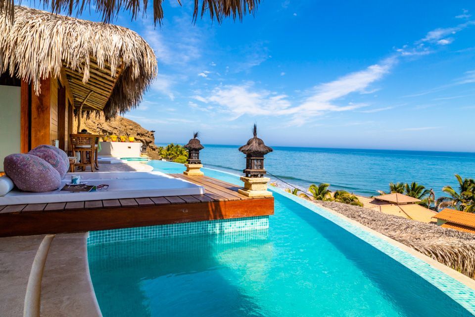 There is a swimming pool with a view of the ocean.