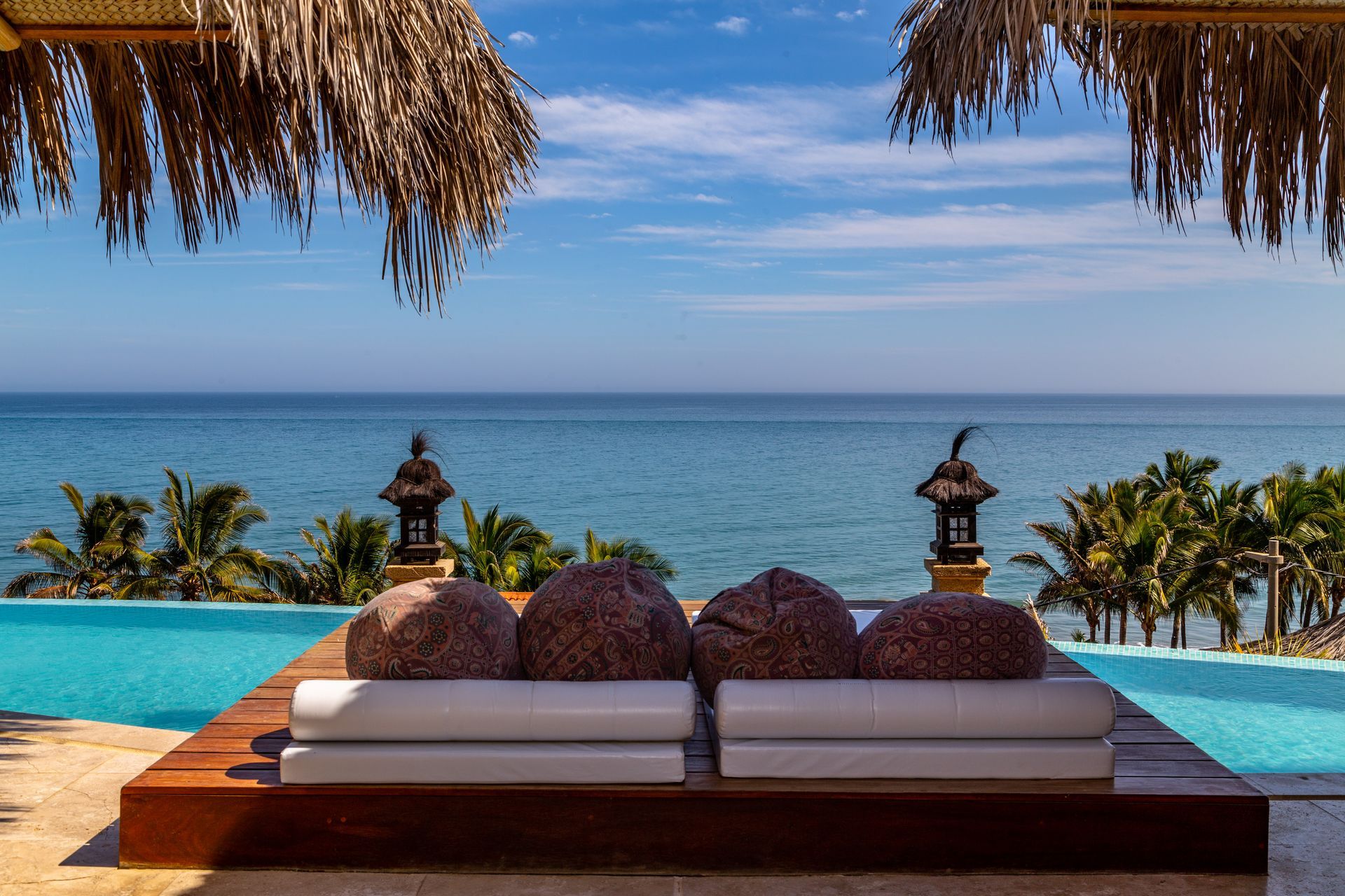 There is a swimming pool with a view of the ocean.