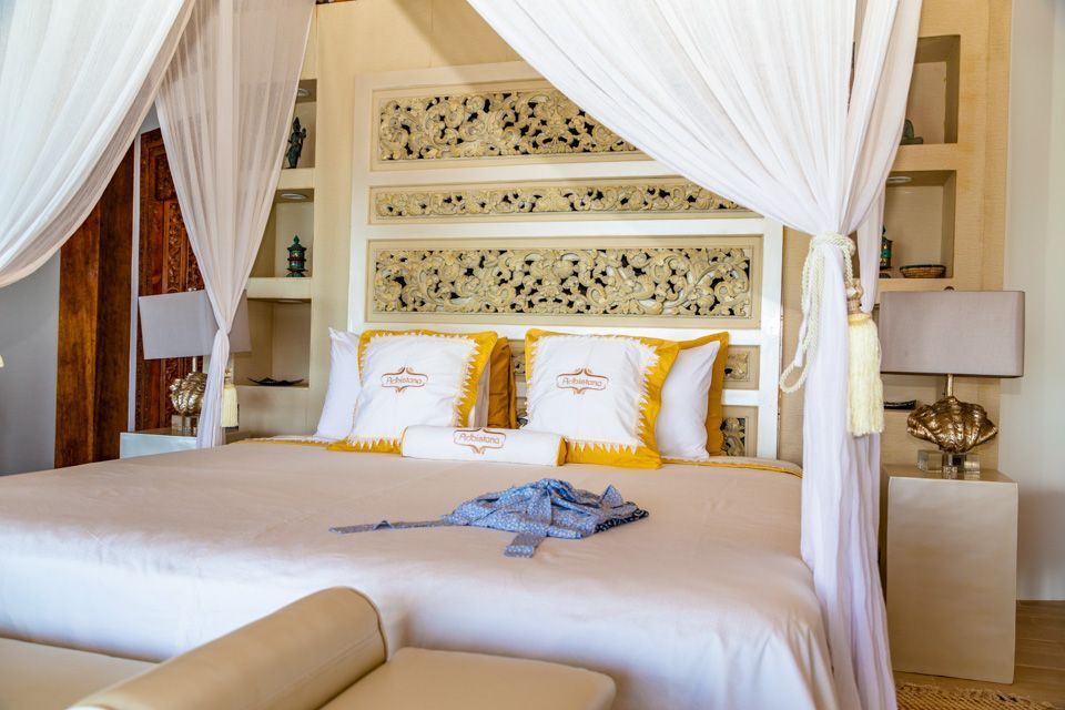 A bedroom with a canopy bed and a couch