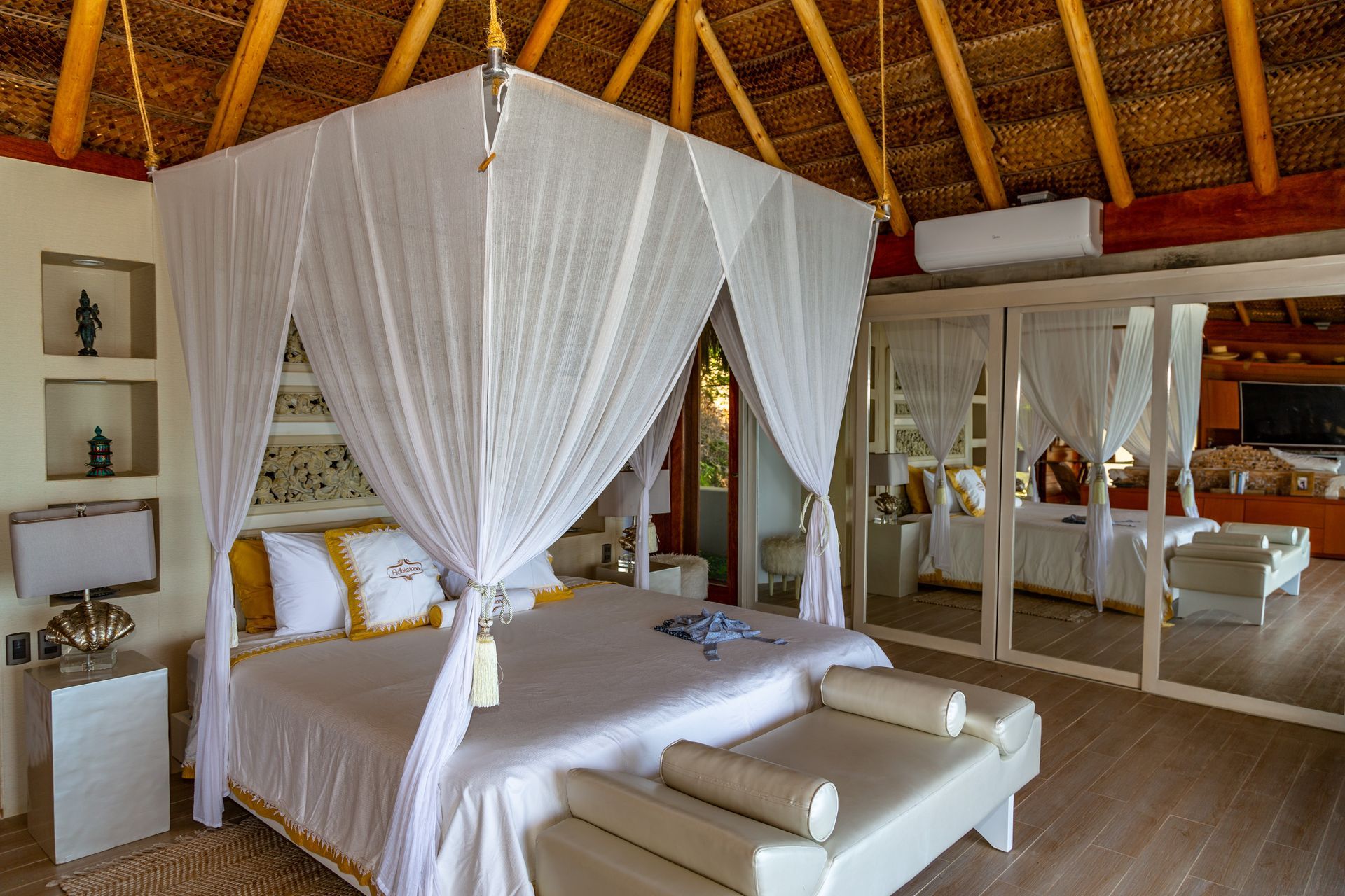 A bedroom with a canopy bed and a bench