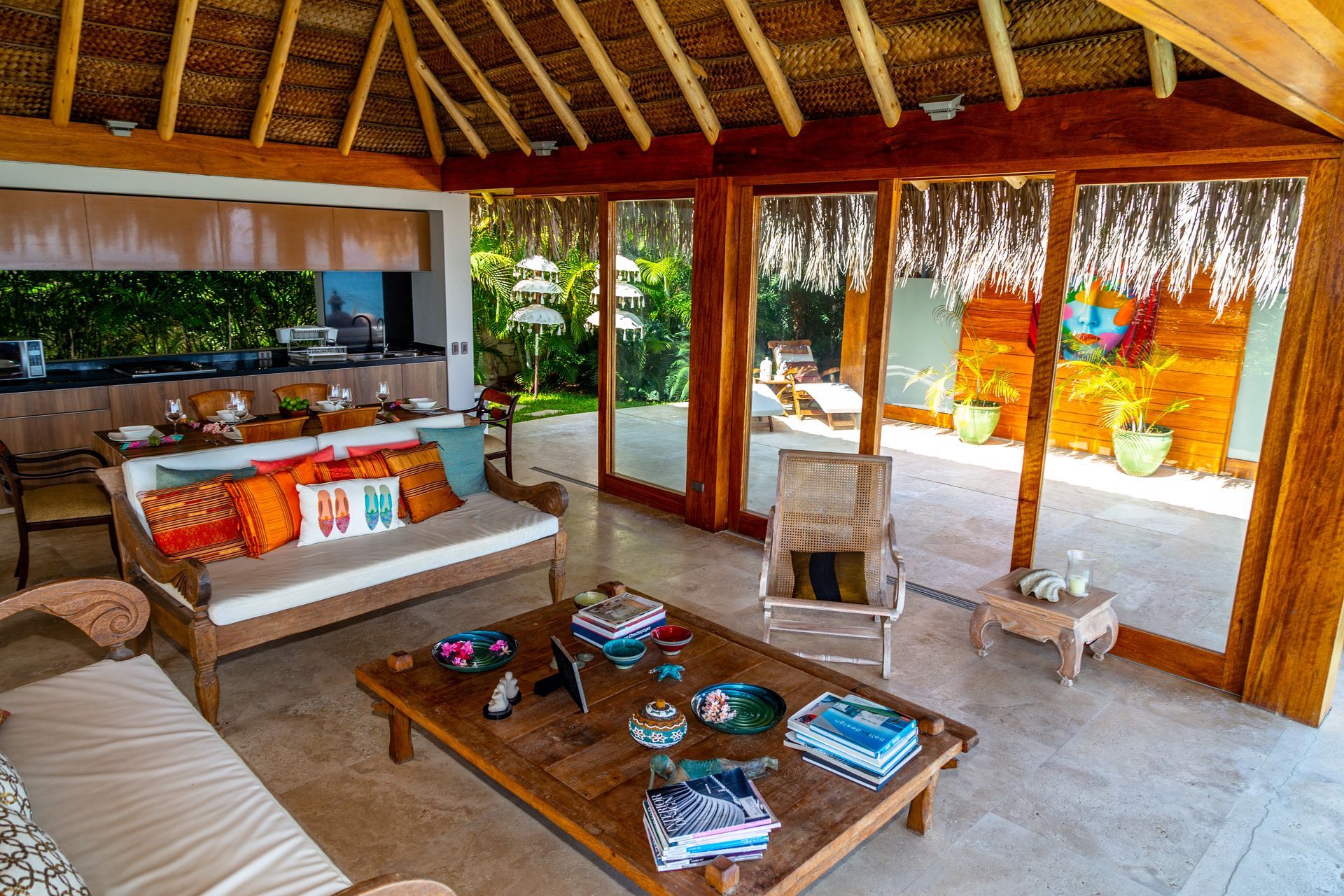 A living room with a couch , table , chairs and sliding glass doors.