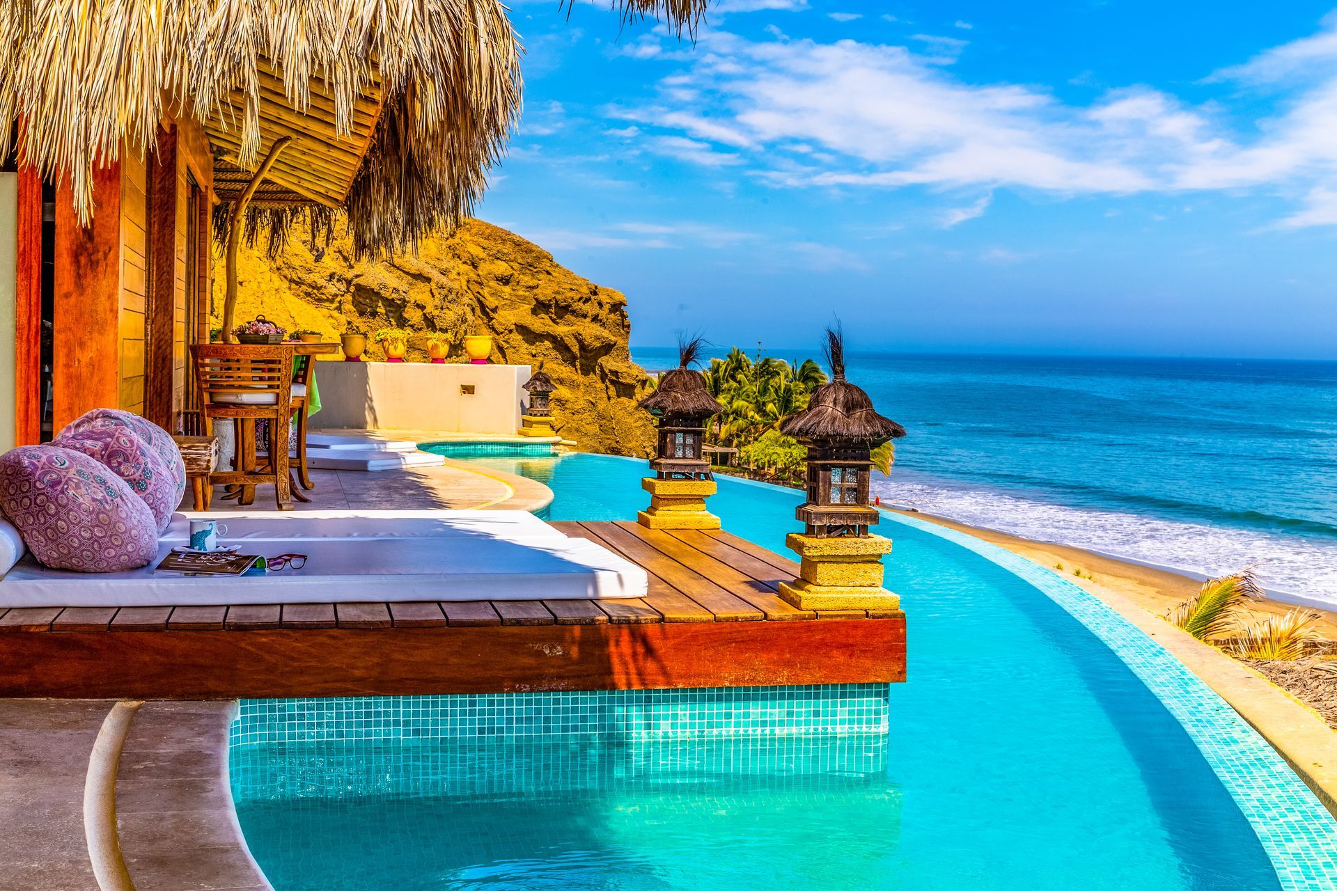 There is a swimming pool with a view of the ocean.