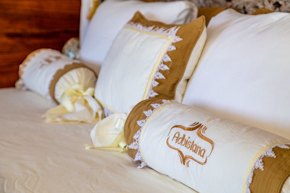 A bed with a lot of pillows on it and a pillow that says ashland on it.