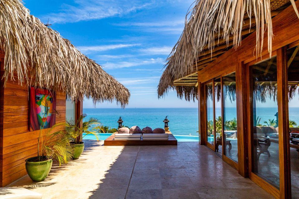A wooden house with thatched roofs overlooking the ocean