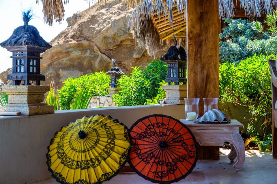 Two umbrellas are sitting on a table under a gazebo.