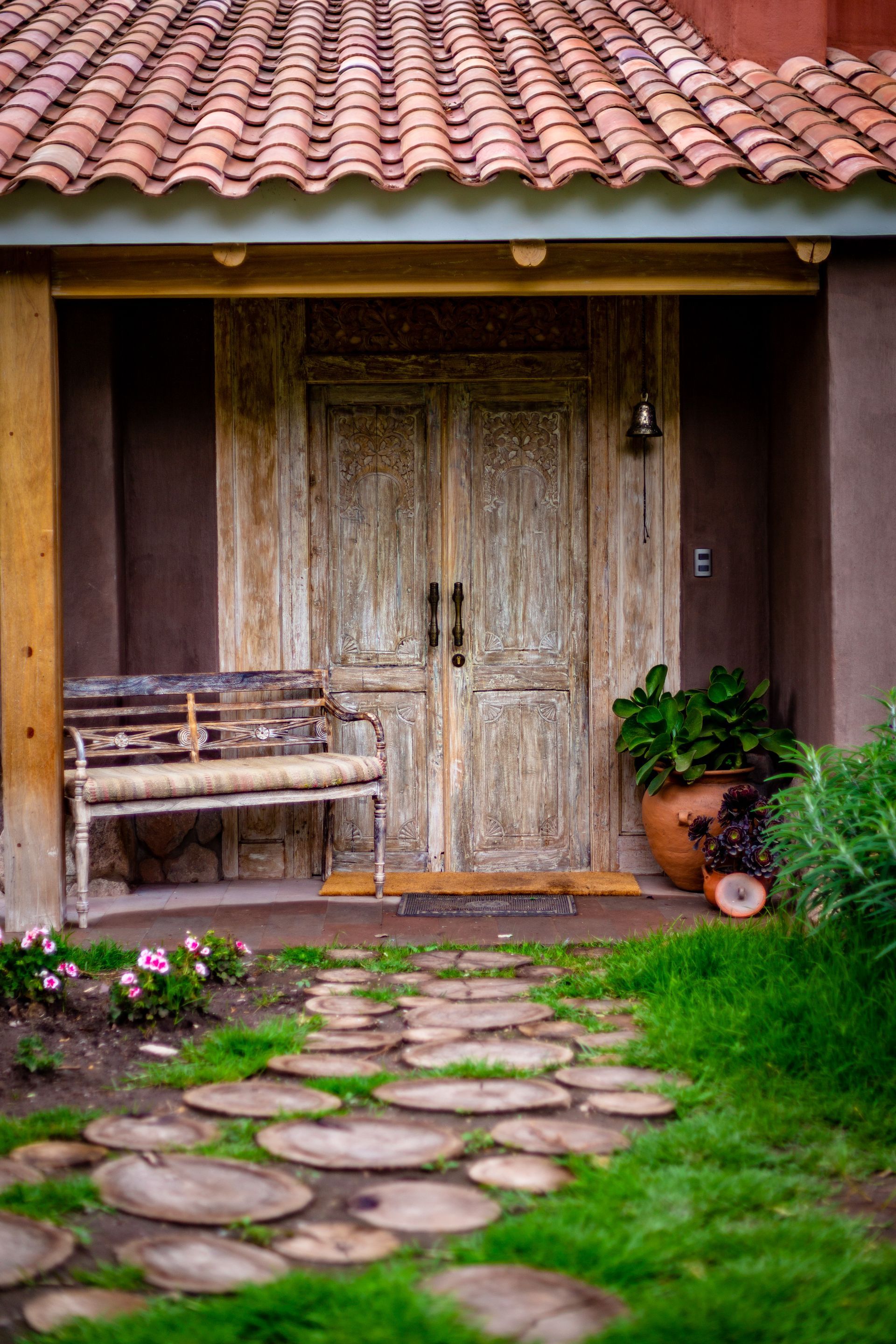 There is a bench in front of the door of a house.
