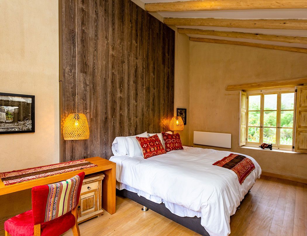 A bedroom with a bed , desk , chair and window.