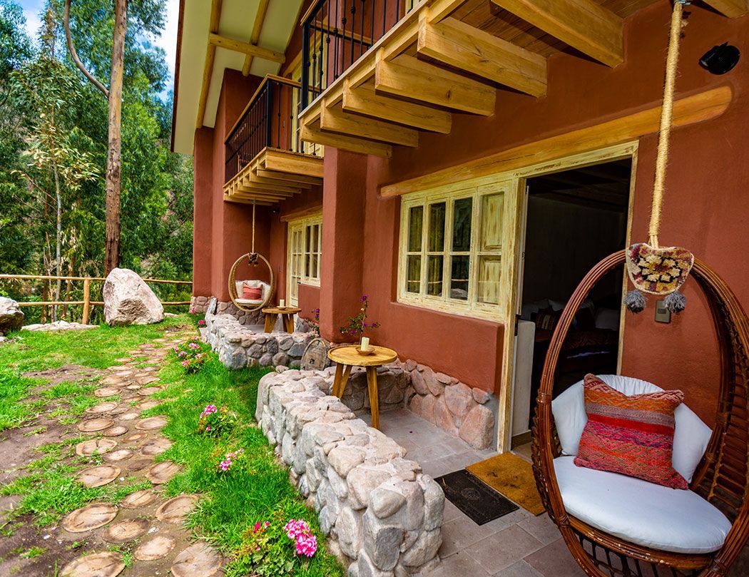 A wicker chair is hanging from the side of a house.