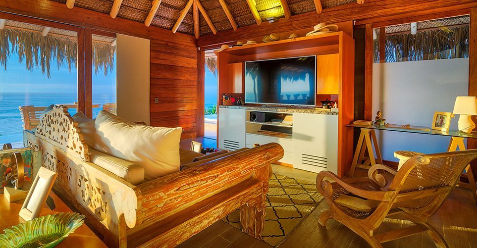 A living room with a couch , chairs , and a flat screen tv.