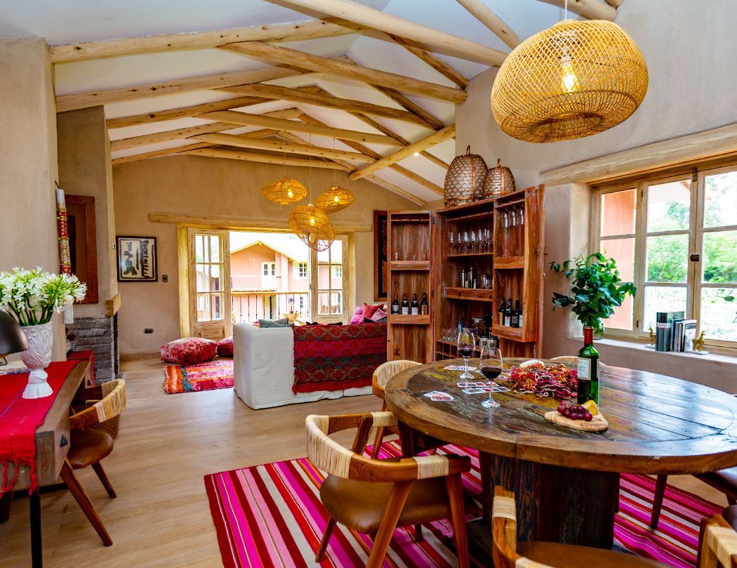 A living room with a table and chairs and a bottle of wine on the table.