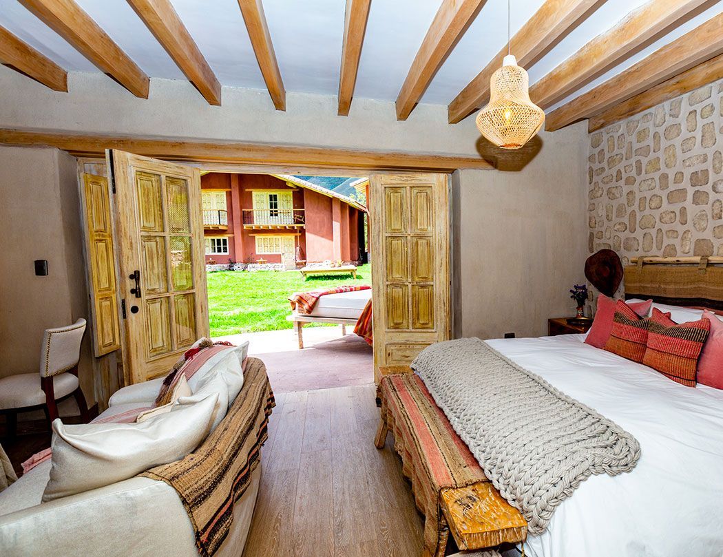 A bedroom with a king size bed , couch , and bench.