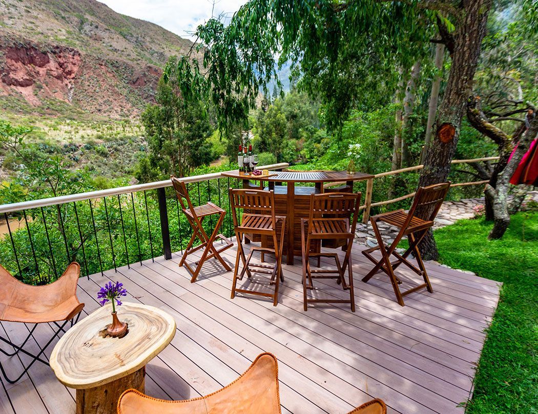 A wooden deck with a table and chairs on it.