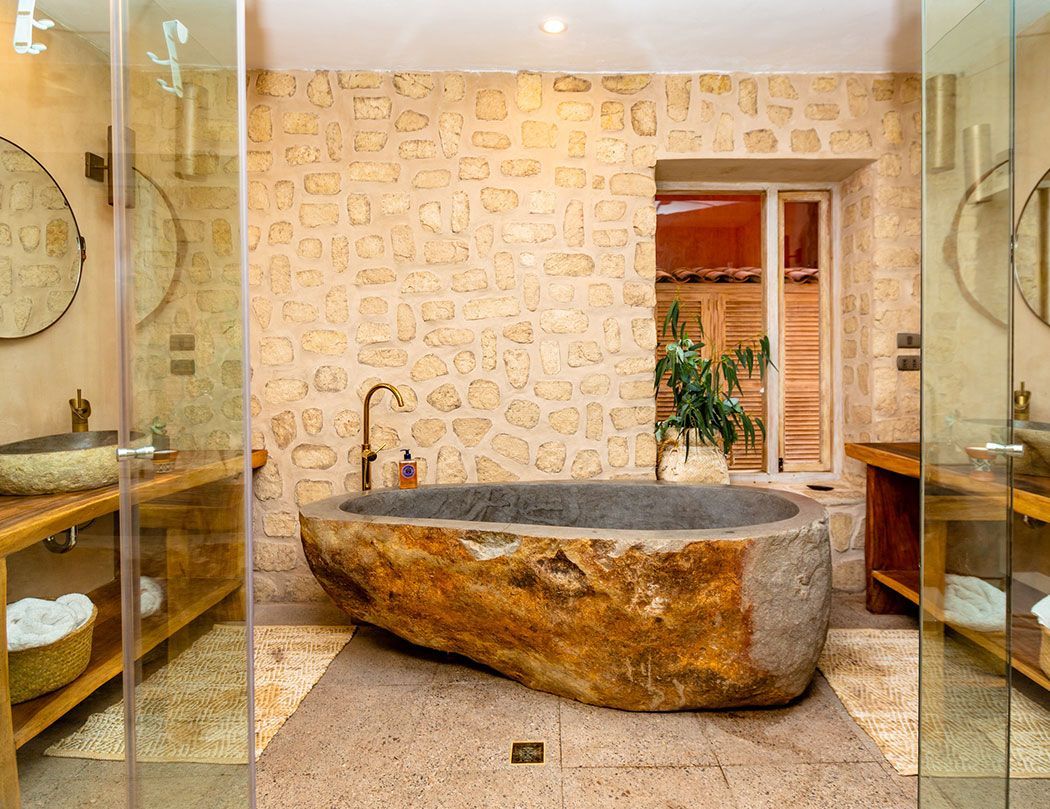 A bathroom with a large stone bathtub in the middle of it.