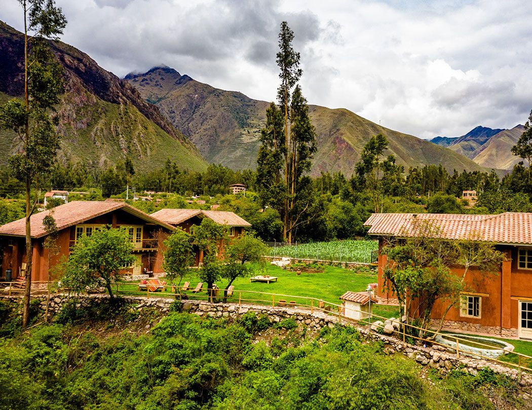 A group of houses sitting on top of a hill with mountains in the background.