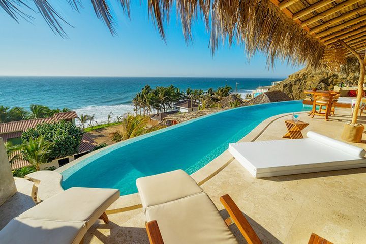 There is a swimming pool with a view of the ocean.