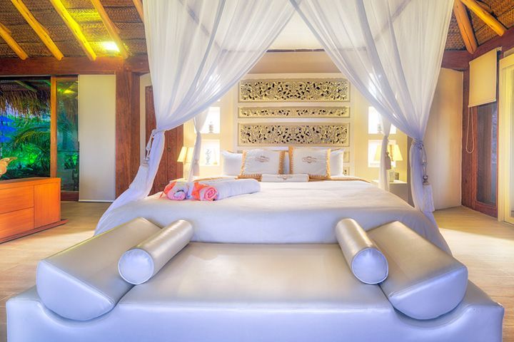 A bedroom with a canopy bed and a couch.