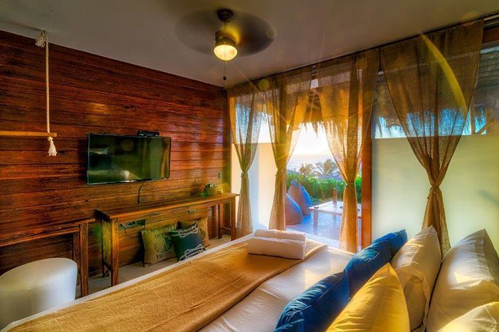 A hotel room with a bed , couch , television and a balcony.