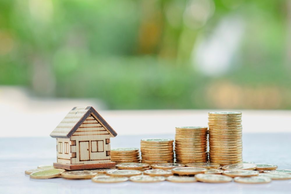 Wooden House Model Next to Stacks of Gold Coins — Midcoast Financial Planning Group in Tuncurry, NSW