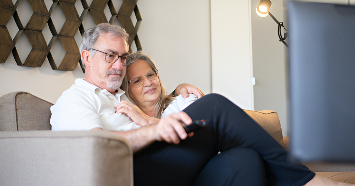 Couple on Couch Watching Tv — Midcoast Financial Planning Group in Tuncurry, NSW